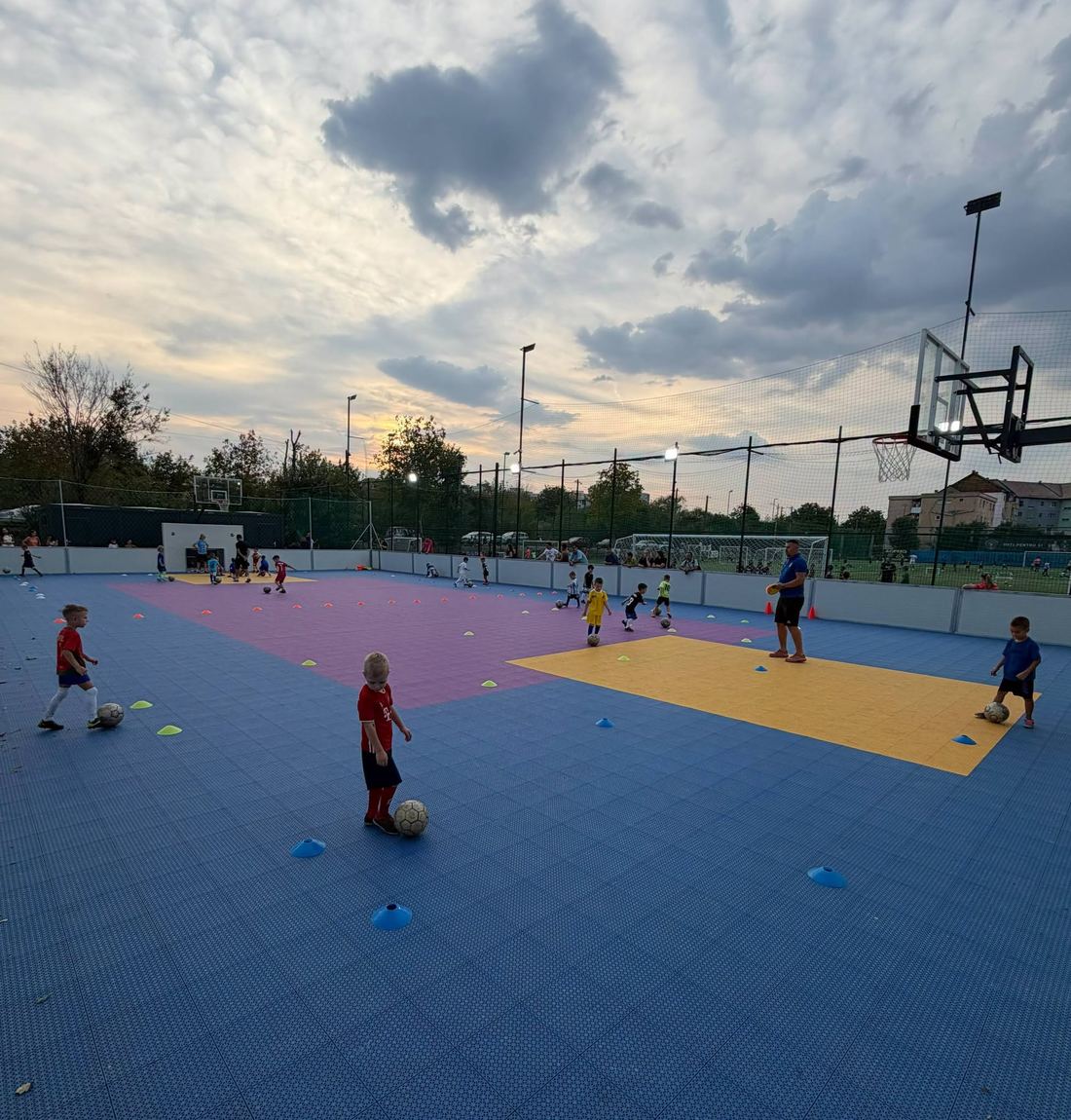 Copii la antrenament pe terenul de Volta, mov, albastru și galben